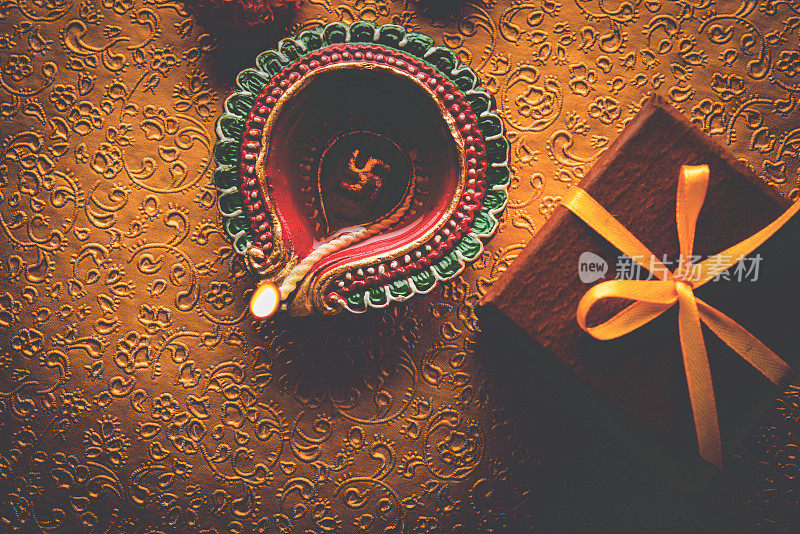 库存照片美丽的排灯节diwali diya与礼物和鲜花，在装饰背景，穆迪照明和选择性焦点